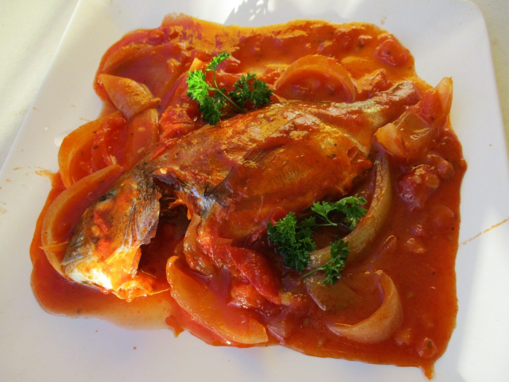 Une daurade en court-bouillon, oignons et persil
