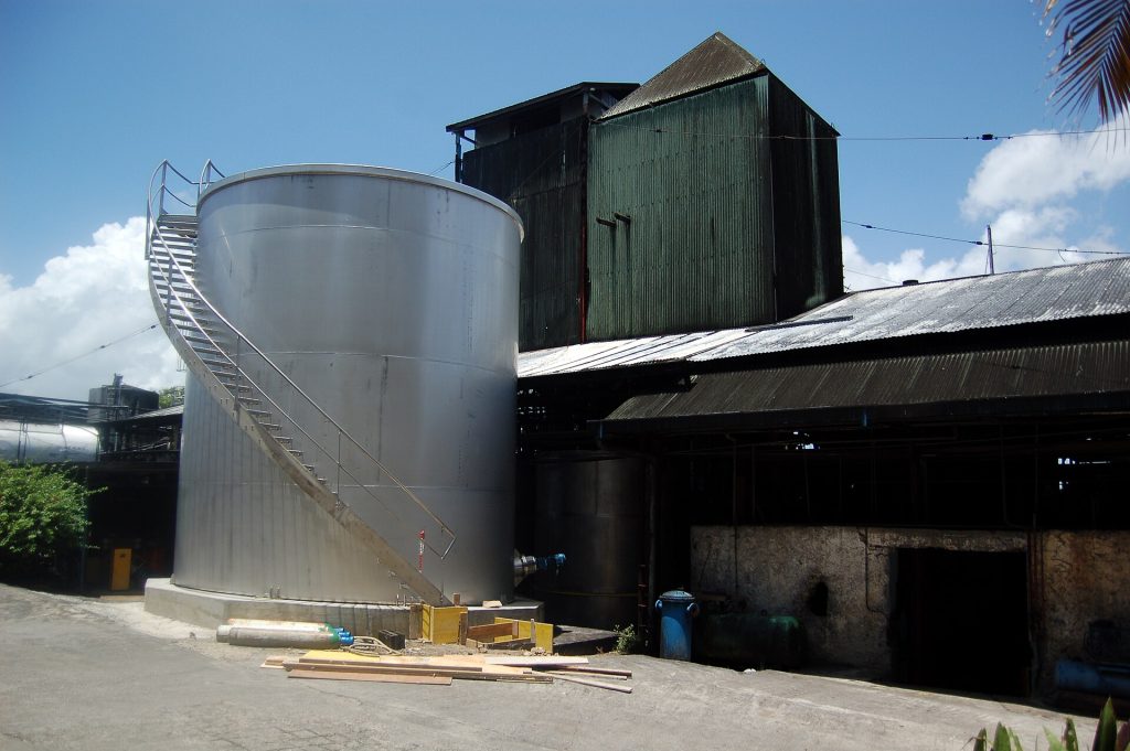 Cuve métallique et bâtiments en tôle de la distillerie de rhum Damoiseau au Moule