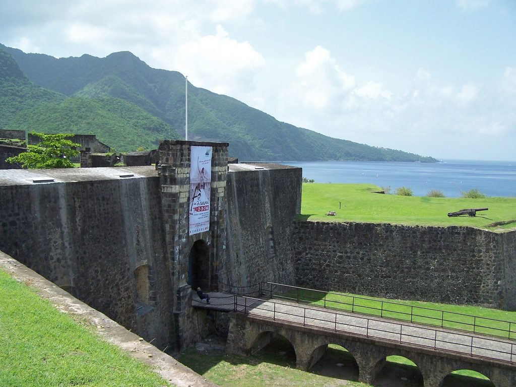 Entrée fortifiée du fort Delgrès, avec les monts Caraïbes et la mer des Caraïbes au fond