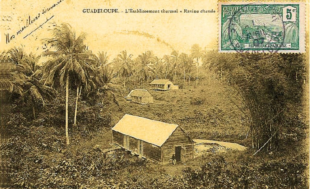Carte postale de 1907 montrant l'établissement thermal de Ravine Chaude parmi les cocotiers