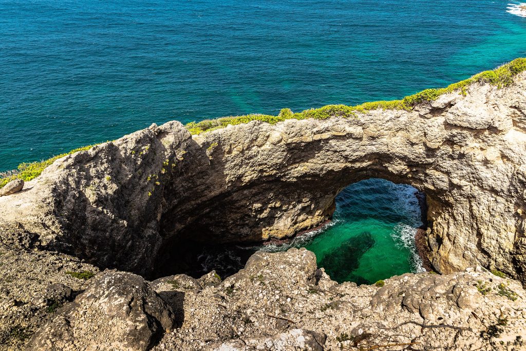Arche calcaire de Gueule Grand Gouffre au-dessus d'un bassin d'eau verte