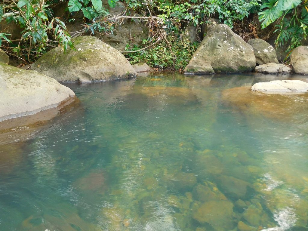 Bassin d'eau limpide entre de gros rochers sur la rivière La Rose, à Goyave