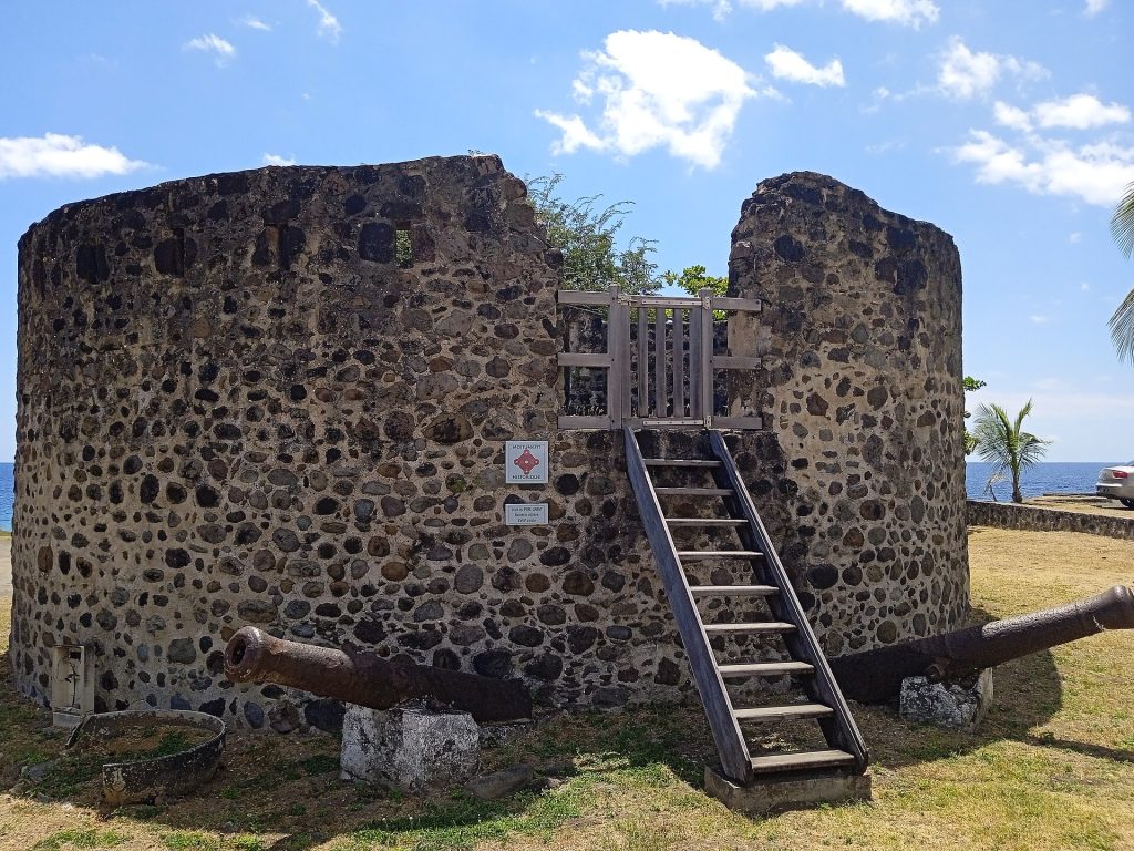 Tour du Père Labat à Baillif, tour ronde en pierre avec escalier et canons, sous un ciel bleu