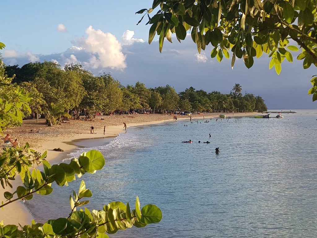Longue courbe de sable de la plage du Souffleur à Port-Louis, bordée d'arbres