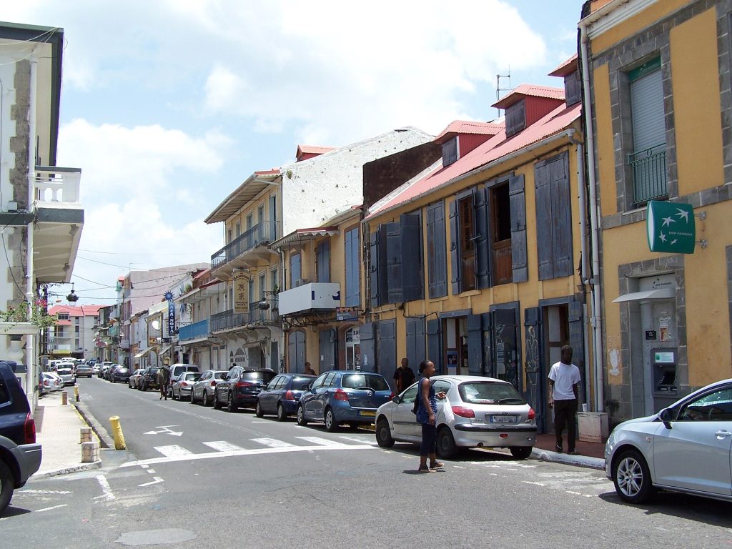 Rue du centre-ville de Basse-Terre bordée de maisons à balcons et volets colorés