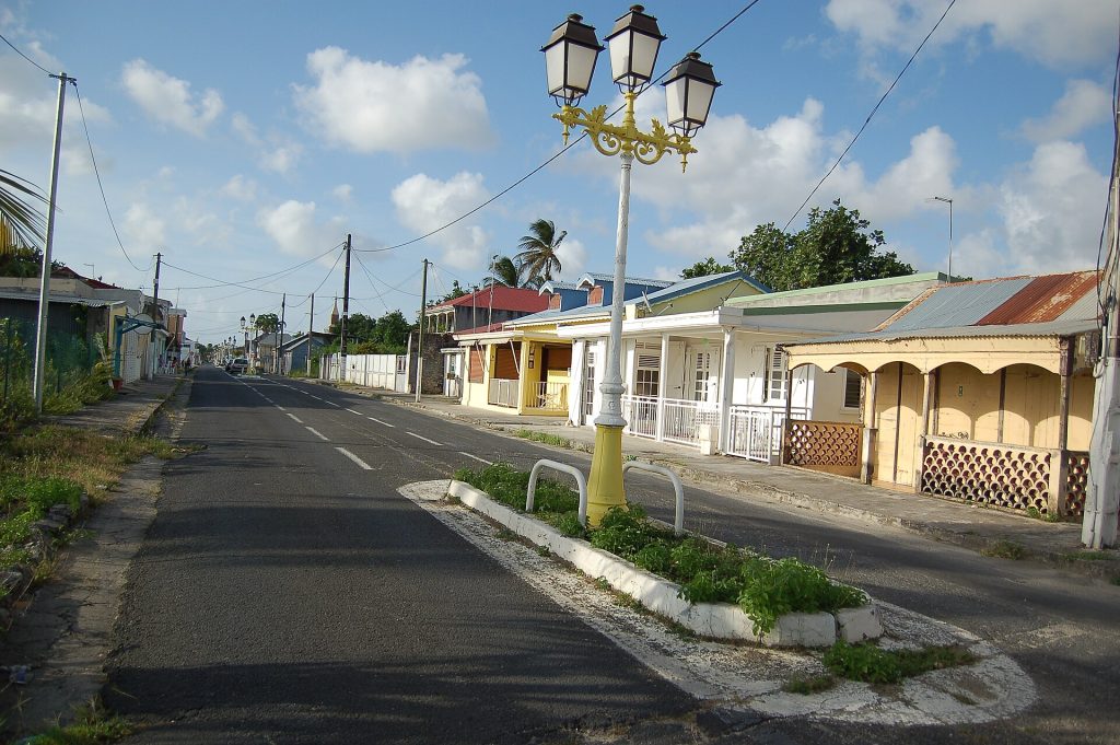Rue du bourg de Port-Louis bordée de maisons créoles basses et de lampadaires